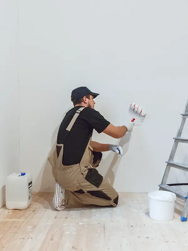 Maler streicht weiße Wand